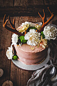 Schokoladen-Passionsfrucht-Torte verziert mit Blüten und Geweih