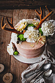 Schokoladen-Passionsfrucht-Torte verziert mit Blüten und Geweih