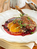 Confit duck leg with oranges, thyme, and cherry sauce