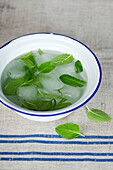 Prepare the mint sauce - place the leaves in ice water