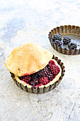 Small blackberry tartlets with shortcrust pastry lids