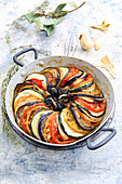 Tian mit Tomaten, Auberginen, Zucchini, Oliven und kandiertem Knoblauch