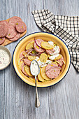 Lukewarm potato salad with Lyon sausage, pistachios and red onions