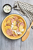 Lauwarmer Kartoffelsalat mit Lyoner Wurst, Pistazien und roten Zwiebeln