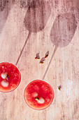 Mocktail mit Litschi, Guave und Rosenknospen (Aufsicht mit Schattenwurf)