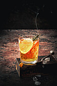 Orangen-Mocktail mit rauchendem Rosmarinzweig