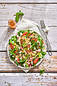 Healthy salad with grapefruit, radishes, spinach and cauliflower with burgundy dressing