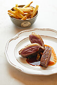 Duck breast with orange sauce and french fries