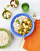 Vegetable curry with cauliflower, chickpeas and coconut chips served with basmati rice