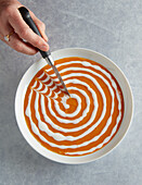 Draw lines with the back of a knife from the center of the spiral to the edge of the dish