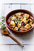 Aubergine rolls stuffed with salami and mozzarella in tomato sauce with marjoram