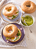 Guacamole,hard-boiled egg,cream cheese and pink radish bagel sandwich