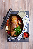 Add the vegetables, garlic and onion to the stuffed lamb roast cooked in a casserole dish