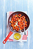 Fry the chopped tomatoes in olive oil and garlic in a frying pan.