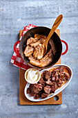 Heat the oil in a cast-iron casserole dish and brown the pieces of meat on all sides. Remove them and do the same with the bacon