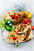 Italian bread with speck, cherry tomatoes, mozzarella, capers and basil