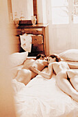 Young couple lying naked on bed