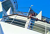 Young couple standing at railing of cruise ship AIDA, Caribbean, America