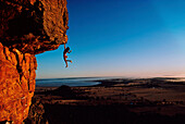Freeclimber Stefan Glowacz hanging from rock, Mount Arapiles, Australia