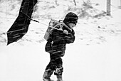 Boy with inverted umbrella in blizzard, Bavaria, Germany