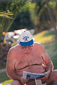 Alter Mann mit nacktem Oberkörper liest Zeitung, Mallorca, Balearen, Mediterrane Länder, Spanien