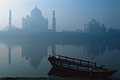 The Jamuna river with ferry boat in front of the Taj Mahal in the morning haze, Agra, Uttar Pradesh, India