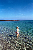 Child is standing in the water, Sardinia Italy