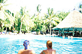 Couple relaxing at pool, people at pool