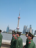 Men in uniforms in front of skyline, Shanghai, China