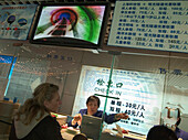 Woman selling tickets, sales counter Shanghai, China