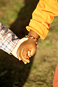 White child and black child holding hands, people