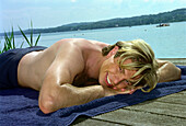 Bathing People, Young man lying on landing stage, Starnberger See, Bavaria