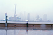 Einsamer Fussgänger schaut über den Huangpu Fluss nach Pudong, Shanghai, China