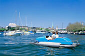 People in a pedal boat on Lake Zurich with view at the town, Zurich, Switzerland