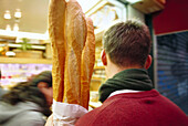 Ein Mann mit drei Baguettes, Paris, Frankreich