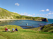 Trippers relaxing on the seaside, Lulworth Cove, South England Great Britain