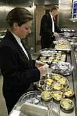 Queen Mary 2, Waiter, Canteen kitchen, Queen Mary 2, QM2 Kellner beim Auspacken von Butterstuecken in der Hauptkueche.