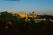 Ein Paar umarmt sich vor Palacio Real und der Kathedrale La Almudena am Abend, Madrid, Spanien, Europa