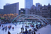 People on an ice skating rink in the evening, Nathan Philipps Square, Toronto, Canada, America