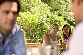 Flirt in beer garden, Two young women and two men flirting in a beer garden, Lake Starnberg, Bavaria, Germany