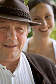 Älterer Mann mit junger Frau im Hintergrund in Biergarten, Bayern, Deutschland