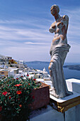 Statue in front of the houses of Thira, Santorini, Cyclades, Greece, Europe