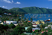 Blick über Häuser auf Segelboote in einer Bucht unter blauem Himmel, Admiralty Bay, Port Elizabeth, Bequia, St. Vincent, Grenadinen, Karibik, Amerika