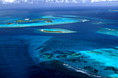 Luftaufnahme der Inselgruppe Tobago Cays unter Wolkenhimmel, Grenadinen, Karibik, Amerika