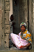 Muslim girl sitting at an entrance, Old Town, Zanzibar, Tanzania, Africa