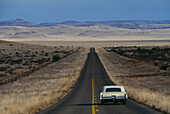 Ein einsames Auto fährt über den Highway, Davis Mountains, Texas, USA