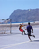 Young men playing football on an asphalt playing field, San Pedro, Sao Vicente, Cape Verde, Africa
