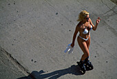 Woman inline skating along Ocean Front Walk, Venice Beach, Los Angeles, California, USA, America