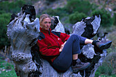 Woman resting in the trunk of an old tree, Hiking tour, South Africa