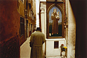 Mann siieht sich ein Heiligenbild in Calle Bembo an, Venedig, Italien